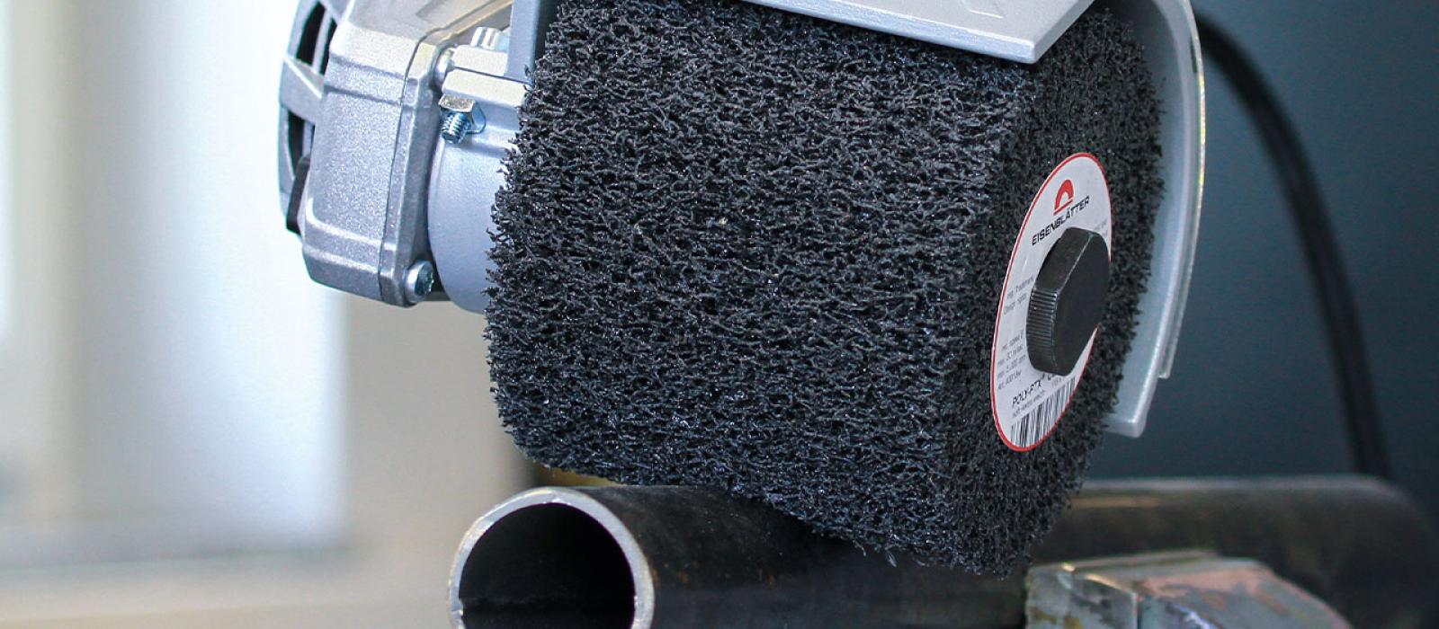 Bild på person som bearbetar en rörprofil med lijärslipmaskin POLY- PTX