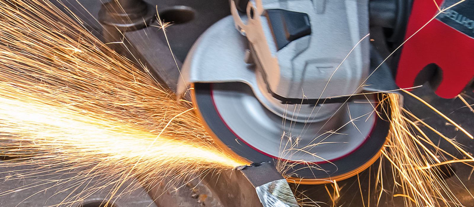 Bild på person som slipar metall med en navrondell
